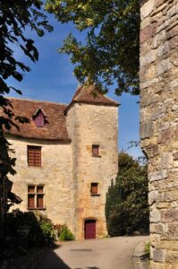 Façade d’une maison en meulière ancienne avec ses pierres apparentes et ses volets en bois.