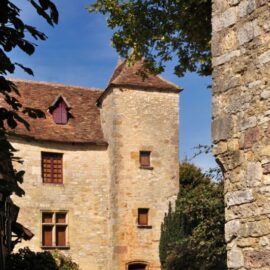 Façade d’une maison en meulière ancienne avec ses pierres apparentes et ses volets en bois.
